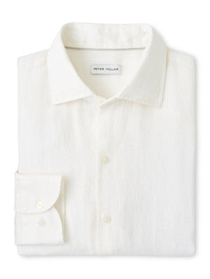 The Shoreside Linen Sport Shirt by Peter Millar is a white, folded sport shirt with a pointed collar, displaying refined craftsmanship.
