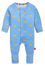 The Baby Boys’ Dip Ship Coverall by Magnetic Me is a blue long-sleeve onesie, crafted from sustainable modal fabric and decorated with a repeating pattern of yellow submarines and white dots, displayed on a white background.