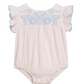 The Louise Misha Baby Girls’ Nusha Romper is crafted from soft cotton gauze in a light pink hue, featuring short ruffled sleeves, an embroidered yoke with delicate blue floral detailing on the chest, and convenient snap closures at the bottom.