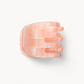 The Machete Mini Claw, a pink rectangular-patterned hair clip with four prongs, is handcrafted from bio-acetate and displayed on a plain white background.