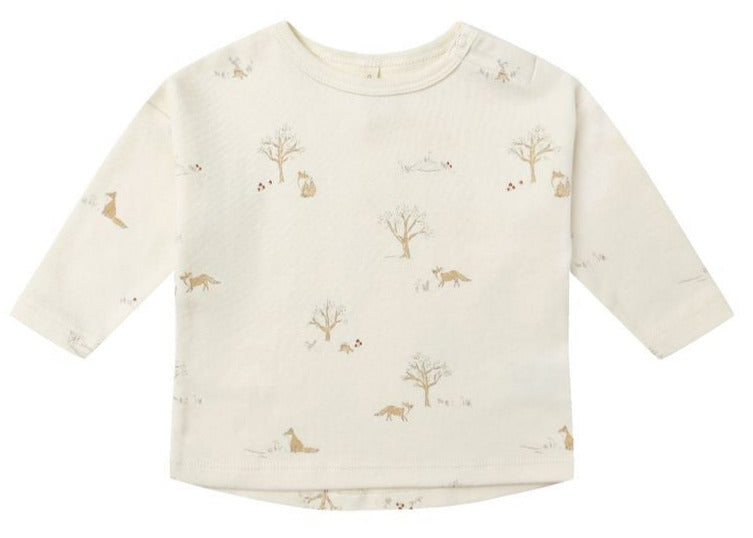 The Quincy Mae Baby Long Sleeve Tee is made from cream-colored organic brushed cotton and features all-over light brown animal and tree prints.