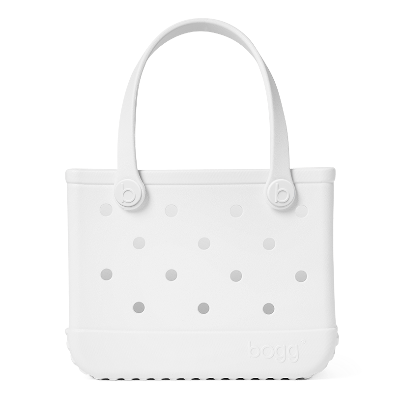 The Bitty Bogg® Bag by Bogg Bags features a white rubber design with circular holes on the front, two sturdy handles, and “bogg” embossed in the bottom right corner. This compact tote is ideal for everyday use and works perfectly as a washable lunch tote.