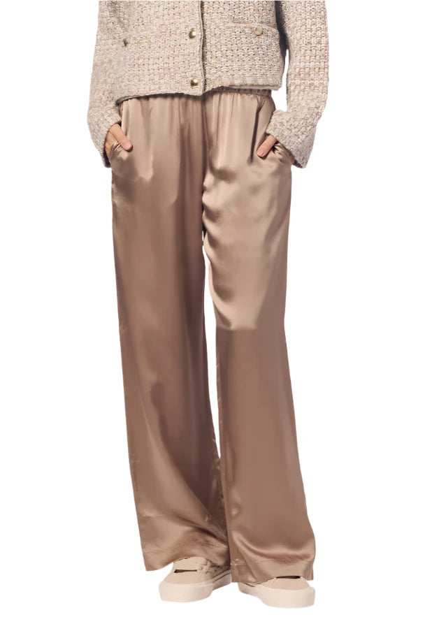 Person wearing a beige tweed jacket and Sablyn's Brynn Silk Pant, with hands in pockets, paired with light-colored shoes.