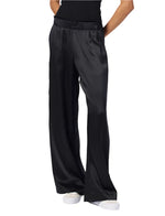 Person wearing Sablyn Brynn Silk Pant in black, complemented by white shoes.