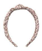 The Girls’ Knotted Headband by Rylee & Cru, designed with a brown and light pink floral pattern on a beige fabric, offers both style and comfort and is shown on a white background.