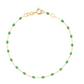 The Gigi Clozeau Classic Gigi Bracelet 6.7" by Gigi Clozeau is crafted with an 18-carat yellow gold chain, embellished with small green beads, and includes a handy adjustable clasp.