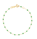 The Gigi Clozeau Classic Gigi Bracelet 6.7" by Gigi Clozeau is crafted with an 18-carat yellow gold chain, embellished with small green beads, and includes a handy adjustable clasp.