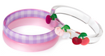 Add a playful, handmade touch to any outfit with the Lillies & Roses Cherry Pink & Red Checkered Bangles. This set includes two plastic bracelets: one in a pink and purple plaid pattern, and another clear bangle adorned with red, pink, and glittery cherry decorations. These Cherry Pink & Red Checkered Bangles are perfect for stacking together or wearing solo for a pop of picnic-inspired charm.