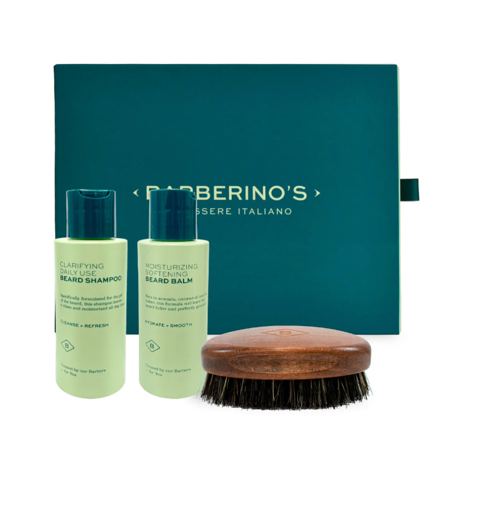 The Beard Grooming Set by Barberino’s includes clarifying beard shampoo, moisturizing beard balm in green bottles, a wooden beard brush, and comes in a stylish green Barberino’s box—everything for premium beard care.