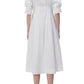 A woman in a white midi dress with shirting inspired designs, wearing the Simkhai Signature Jazz Dress by Simkhai.