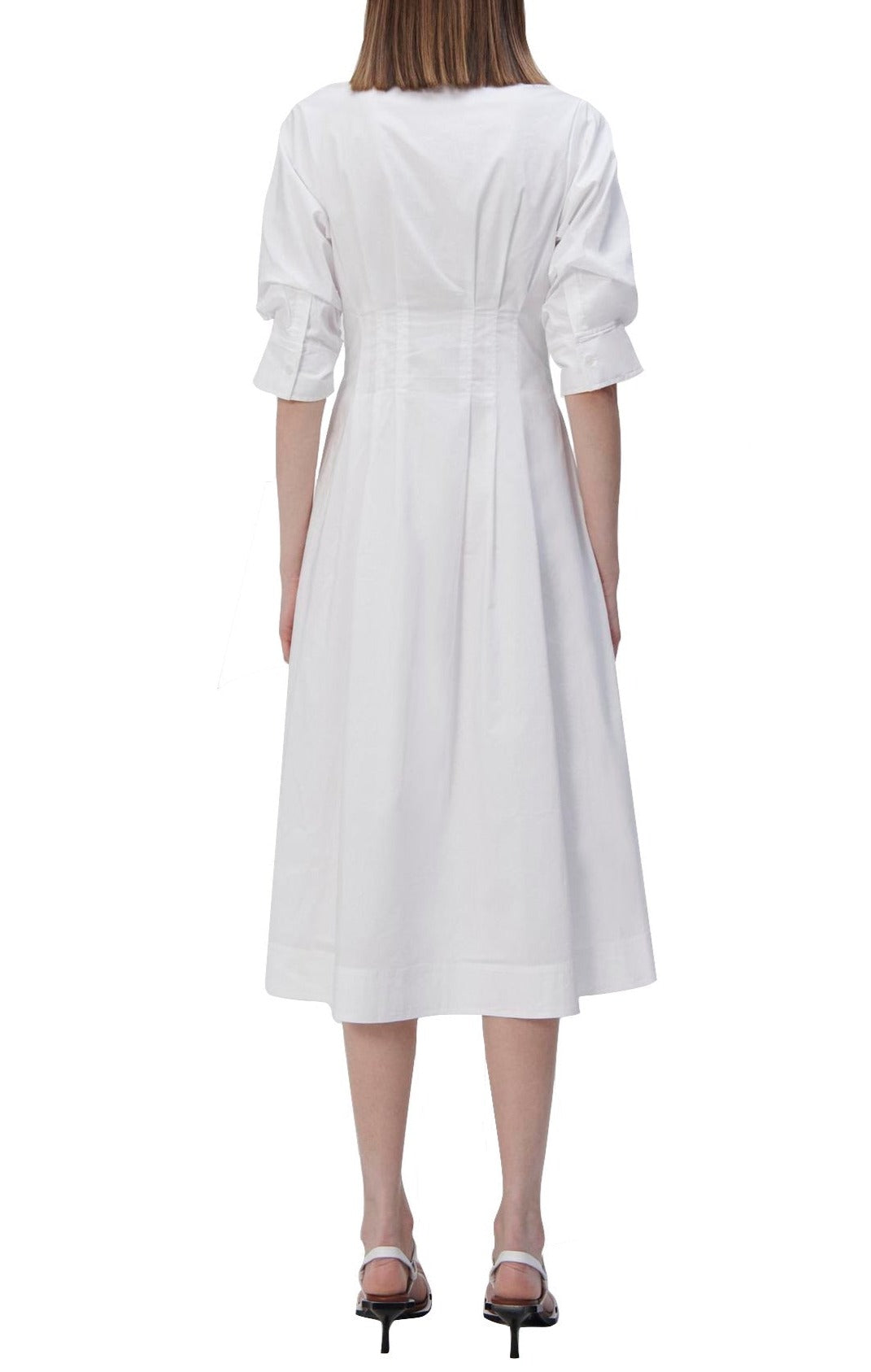 A woman in a white midi dress with shirting inspired designs, wearing the Simkhai Signature Jazz Dress by Simkhai.