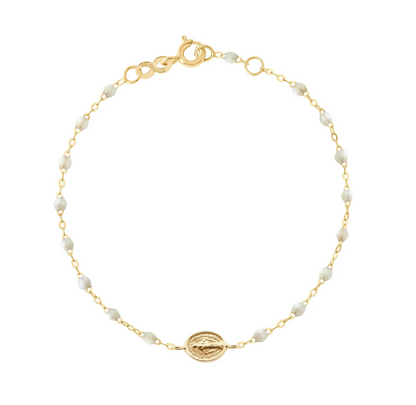 The Madone Charm Bracelet 6.7" by Gigi Clozeau features an 18-carat gold chain, elegant resin pearls, a central round gold charm, and a lobster clasp—a timeless accessory for any occasion.