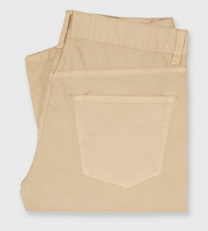 A folded pair of Sid Mashburn's Slim Straight 5-Pocket Pant in beige Italian twill, showcasing a visible back pocket, is elegantly displayed on a white background.