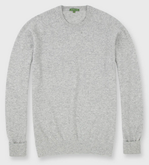 The Sid Mashburn Classic Crewneck Cashmere Sweater in light grey is shown laid flat, showcasing its ribbed cuffs, hem, and neckline.