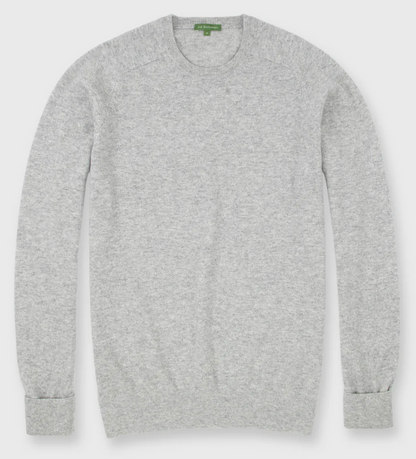 The Sid Mashburn Classic Crewneck Cashmere Sweater in light grey is shown laid flat, showcasing its ribbed cuffs, hem, and neckline.
