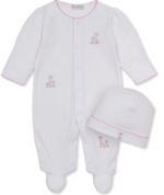 The Kissy Kissy Baby Just Giraffes Footie with Hat Set features a white footed onesie with pink trim and adorable giraffe embroidery, crafted from ultra-soft Pima cotton for delicate skin. This charming set also includes a matching white beanie adorned with a sweet pink giraffe design, creating a delightful giraffe-themed look.