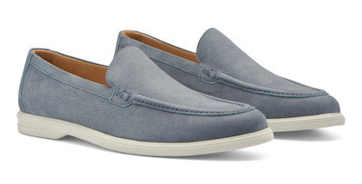 The Excursionist Nubuck Venetian Loafer by Peter Millar is a lightweight Brazilian loafer in light blue suede, featuring white rubber soles and tan interior lining, displayed against a white background.
