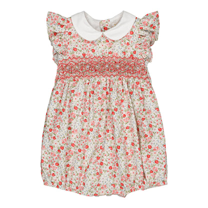 The Kidiwi Baby Girls' Julyne Smocked Girl Romper features a white Peter Pan collar, short ruffled sleeves, pink and green floral print, and charming smocking detail across the chest.