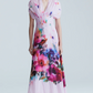 A person wearing the Lela Rose Watercolor Floral Cotton Voile Isabel Dress, featuring light pink hues, short sleeves, a v-neck, and a watercolor floral print, stands against a plain background.