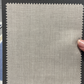 A swatch of light beige textured fabric labeled "Samuelsohn Slim Fit Flat Front Wool Pants," ideal for slim dress pants, is held by a hand on the right edge.