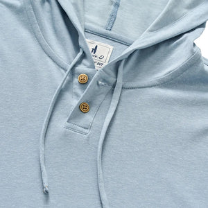 The Jase Hoodie by Johnnie-O features a light blue slub knit fabric, a drawstring hood, two brown buttons on the placket, and a white tag sewn inside the collar. Part of the Hangin’ Out collection, this cotton-blend hoodie combines comfort and style for everyday wear.