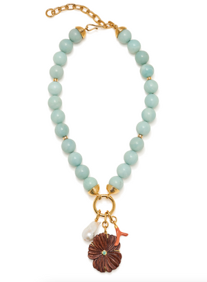 Lizzie Fortunato’s Desert Bloom Necklace showcases chunky aqua amazonite beads, gold-toned hardware, and three distinctive charms: a brown flower, a white pearl-like bead, and a petite red branch-shaped accent.