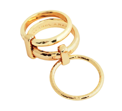 The Farrier Triple Connected Ring by Anabel Aram features three interlocking gold rings with a polished finish—two stacked horizontally and one hanging vertically for a unique jewelry design.