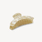 The Machete Jumbo Heirloom Claw is a large, beige marbled hair clip crafted from premium Italian acetate. It features a curved design and interlocking teeth to ensure a secure hold, making it ideal for thick hair. Shown here on a plain white background.