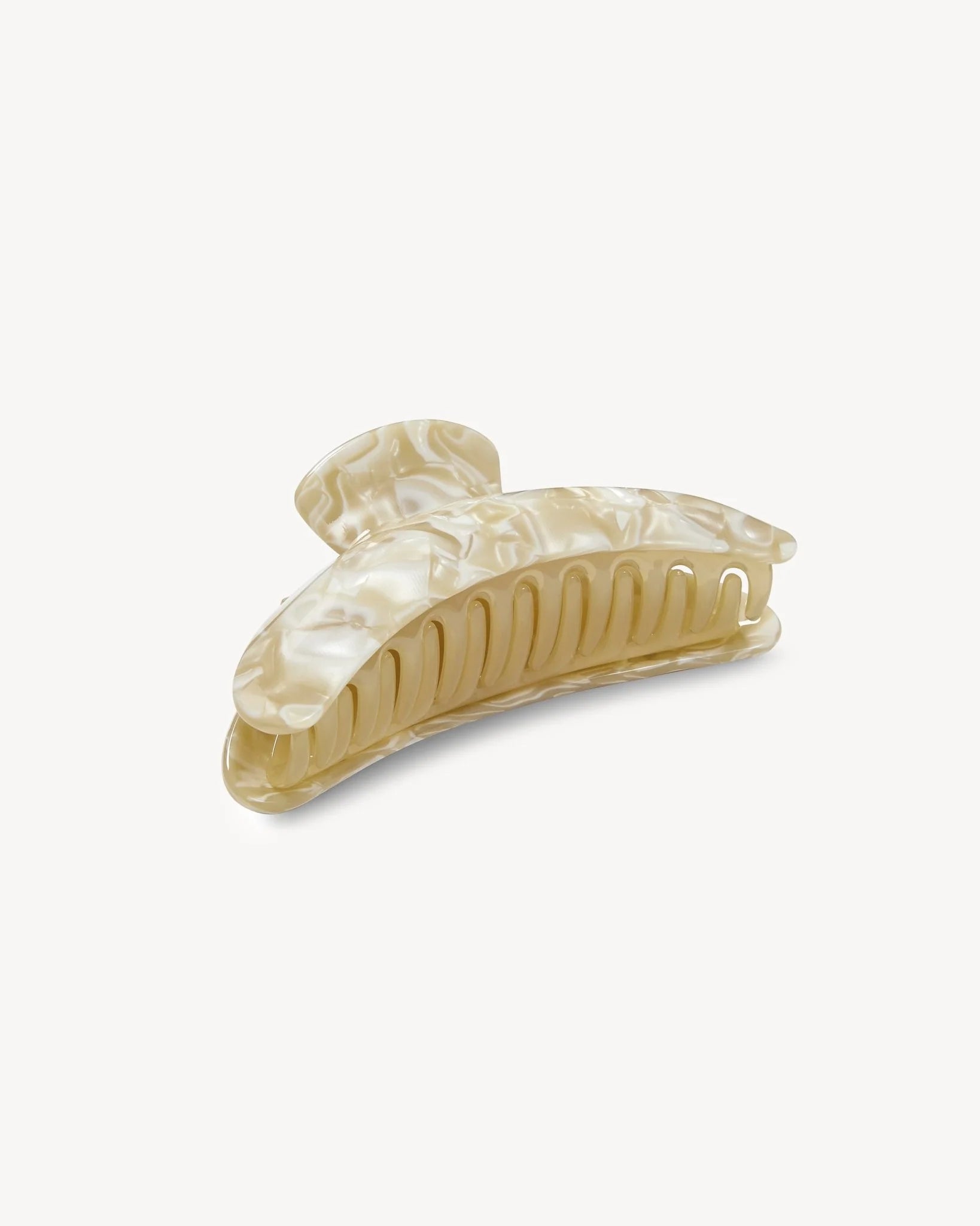 The Machete Jumbo Heirloom Claw is a large, beige marbled hair clip crafted from premium Italian acetate. It features a curved design and interlocking teeth to ensure a secure hold, making it ideal for thick hair. Shown here on a plain white background.