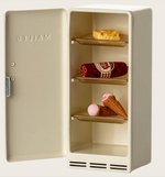 An off-white Maileg Fridge, Mouse with its door open, displaying a cookie, a roll of salami, and an ice cream cone on the shelves—perfect dollhouse accessories to inspire imaginative storytelling play.