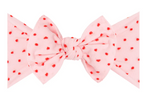 A Baby Bling Patterned Shabby Knot Headband in pink featuring red dots on a white background.