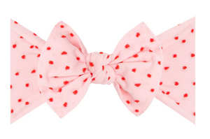 A Baby Bling Patterned Shabby Knot Headband in pink featuring red dots on a white background.