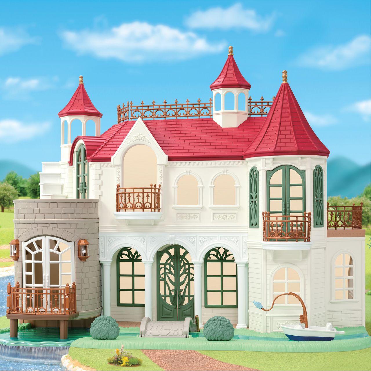 Presenting the Calico Critters Red Roof Riverside Manor: a delightful toy mansion featuring eye-catching red roofs, white walls, green doors and windows, beautiful balconies, and a small pond in front—all set in a lush grassy outdoor scene. This charming castle-style home boasts a whimsical drawbridge garden that enhances its enchanting appeal.
