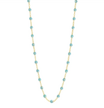 The Gigi Clozeau Classic Gigi Necklace 16.5" by Gigi Clozeau showcases an 18 carat yellow gold chain decorated with vibrant turquoise beads, creating a captivating piece of jewelry.