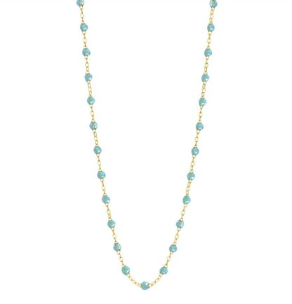 The Gigi Clozeau Classic Gigi Necklace 16.5" by Gigi Clozeau showcases an 18 carat yellow gold chain decorated with vibrant turquoise beads, creating a captivating piece of jewelry.