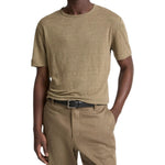 A person wearing the Vince Linen Jersey Shortsleeve Crew in light brown, tucked into matching pants with a black belt.