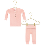 Lou Lou & Company’s Baby Girls’ and Girls’ Piper Plush Knit Top & Bottoms—a pink, long-sleeve button-up shirt paired with matching pants, both made from plush, silky-soft knit fabric—hang on gold hangers against a white background.