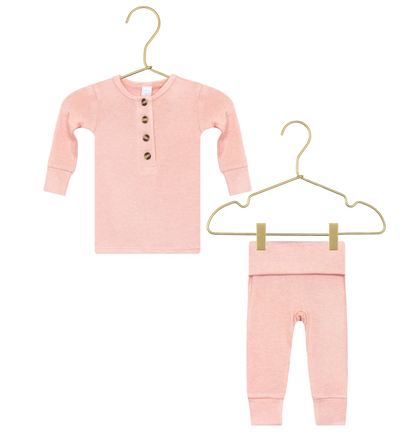 Lou Lou & Company’s Baby Girls’ and Girls’ Piper Plush Knit Top & Bottoms—a pink, long-sleeve button-up shirt paired with matching pants, both made from plush, silky-soft knit fabric—hang on gold hangers against a white background.