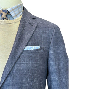 Mannequin wearing Canali Kei Blue/Grey Plaid Blazer, beige sweater, blue plaid shirt, patterned tie, and light blue pocket square, isolated on white background.