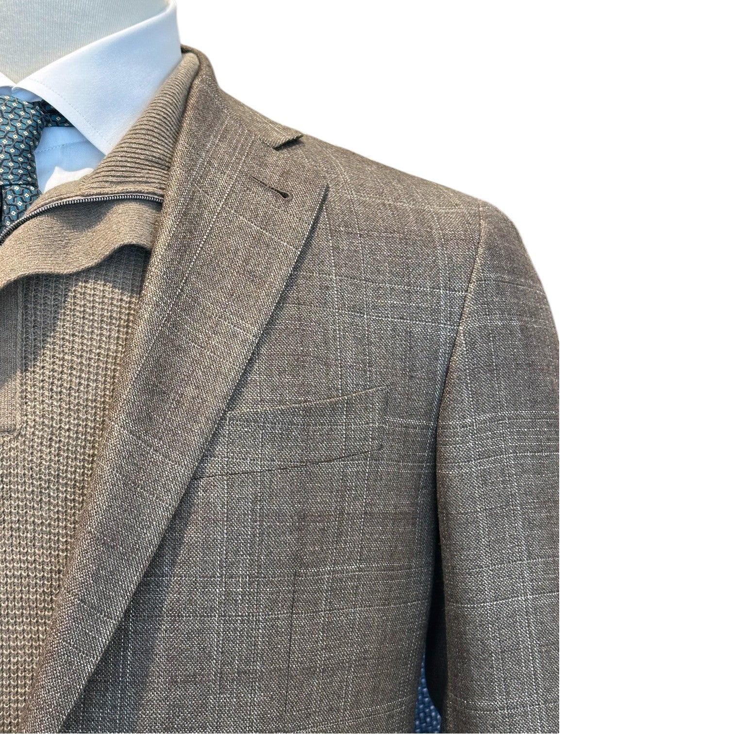 A mannequin wears the Canali Kei Brown/Tan Plaid Blazer, featuring structured tailoring, over a textured sweater, blue dress shirt, and patterned tie; shown from the chest up against a white background.