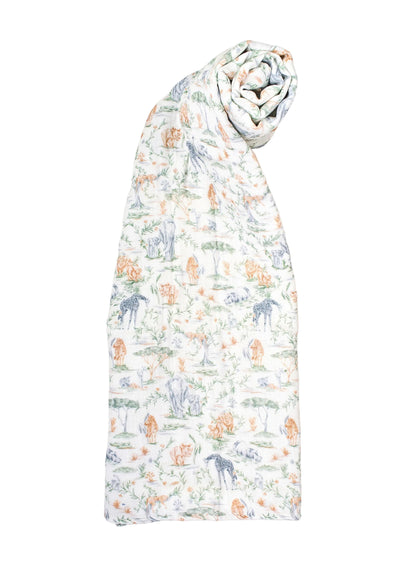 A rolled-up Timo & Violet Shawl Blanket made from white organic cotton, featuring a pastel animal and nature print with elephants, giraffes, and trees.