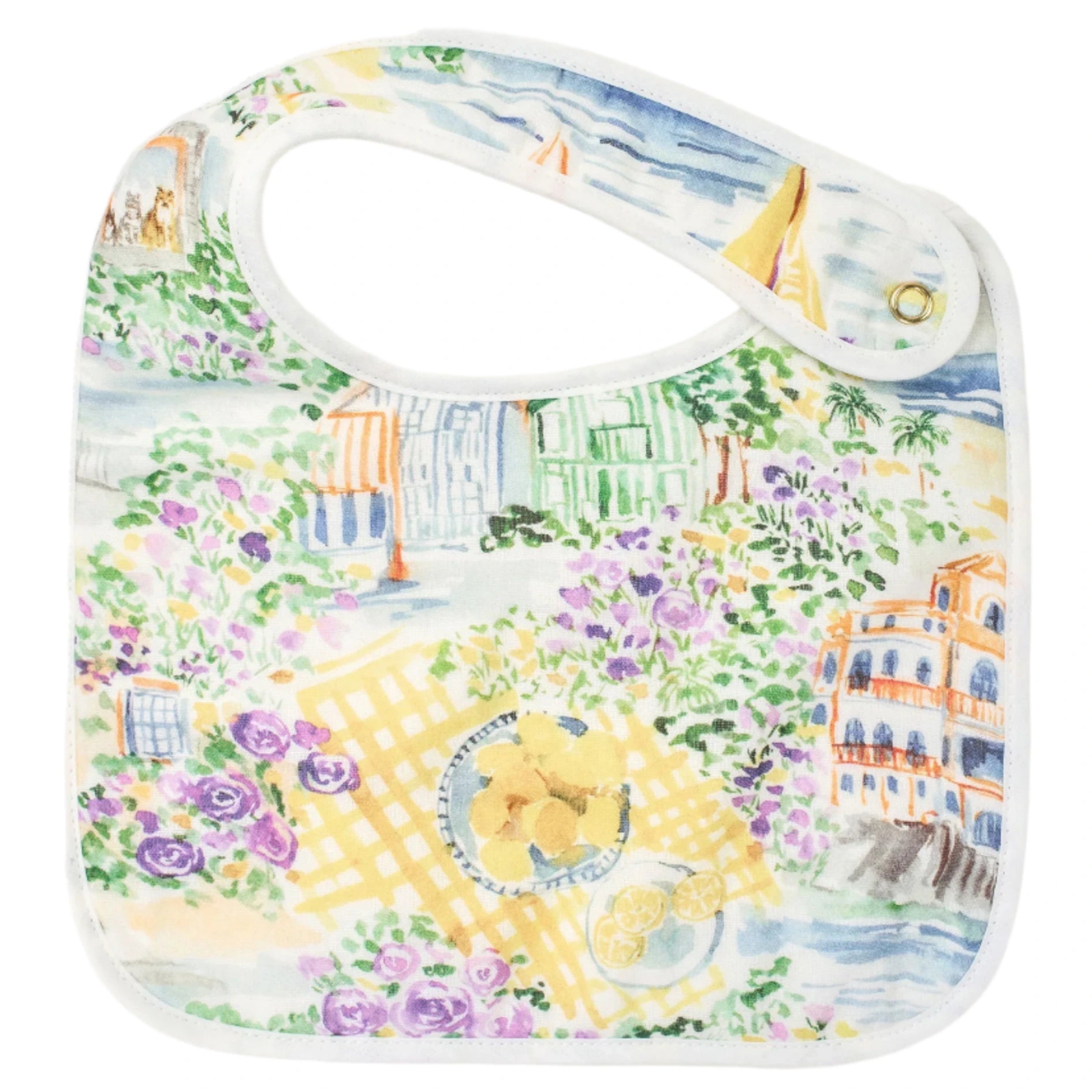 The Perfect Bib by Timo & Violet features a vibrant scenic print with flowers, buildings, and lemons at a picnic. Designed for little ones, it has a convenient snap closure on one corner for easy use.
