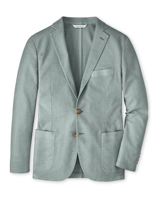 The Peter Millar Weekend Soft Jacket is a light gray-blue men's cotton-stretch blazer featuring two brown buttons, notch lapels, three front pockets, and a subtle textured fabric, shown against a plain white background.
