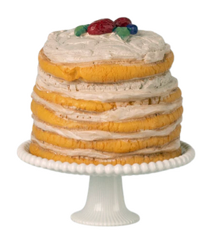The Maileg Off White Party Cake and Cake Stand - Mouse features a beautifully layered yellow cake topped with white frosting and festive red and green decorations, elegantly displayed on a white cake stand—an ideal centerpiece for farmhouse-themed birthday celebrations.