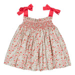 The Kidiwi Baby Girls' and Girls' Sariette Smocked Blouse features a smocked bodice, cherry red print shoulder bows, and red and pink floral patterns on white 100% cotton.