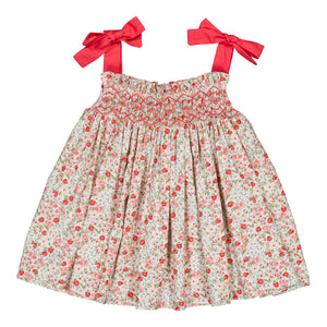 The Kidiwi Baby Girls' and Girls' Sariette Smocked Blouse features a smocked bodice, cherry red print shoulder bows, and red and pink floral patterns on white 100% cotton.