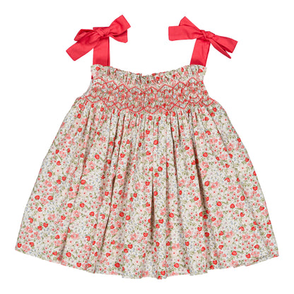 The Kidiwi Baby Girls' and Girls' Sariette Smocked Blouse features a smocked bodice, cherry red print shoulder bows, and red and pink floral patterns on white 100% cotton.