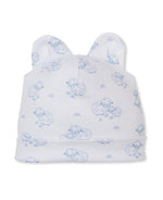 The Sweet Sheep Hat by Kissy Kissy is a white baby hat adorned with a blue sheep print, made from soft Pima cotton and accented with two small fabric ears on top.