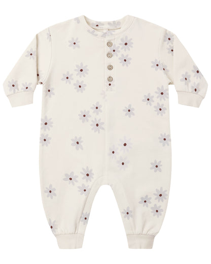 The Quincy Mae Baby Relaxed Fleece Jumpsuit features a cream color, long sleeves, delicate floral pattern, five front buttons, and ribbed cuffs at the wrists and ankles. This cozy essential is perfect for everyday comfort.