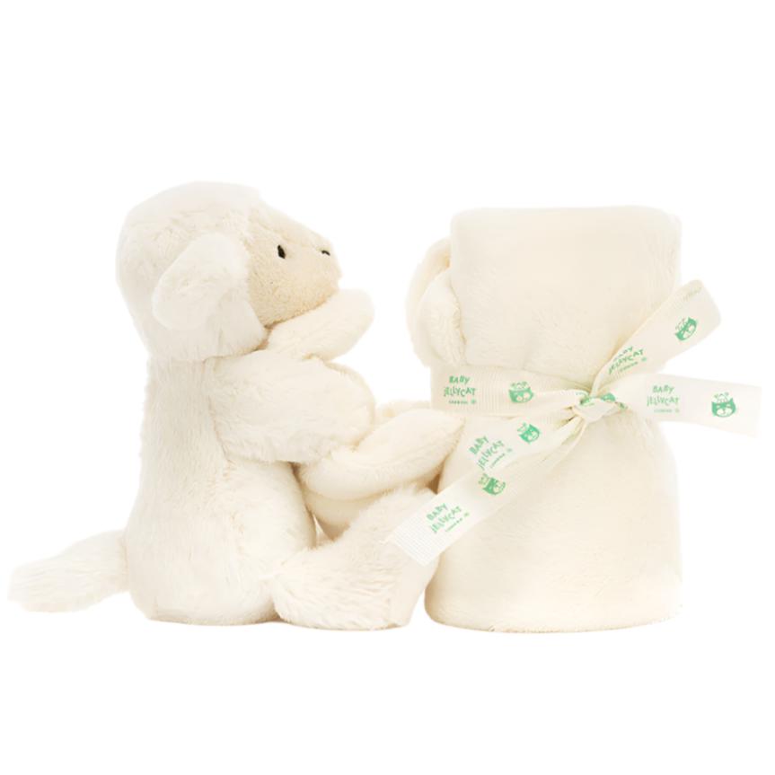 The Jellycat Bashful Lamb Soother, made from recycled fibers, showcases a plush lamb toy sitting next to a rolled cream-colored blanket tied with a ribbon, making it an ideal charming gift for newborns.